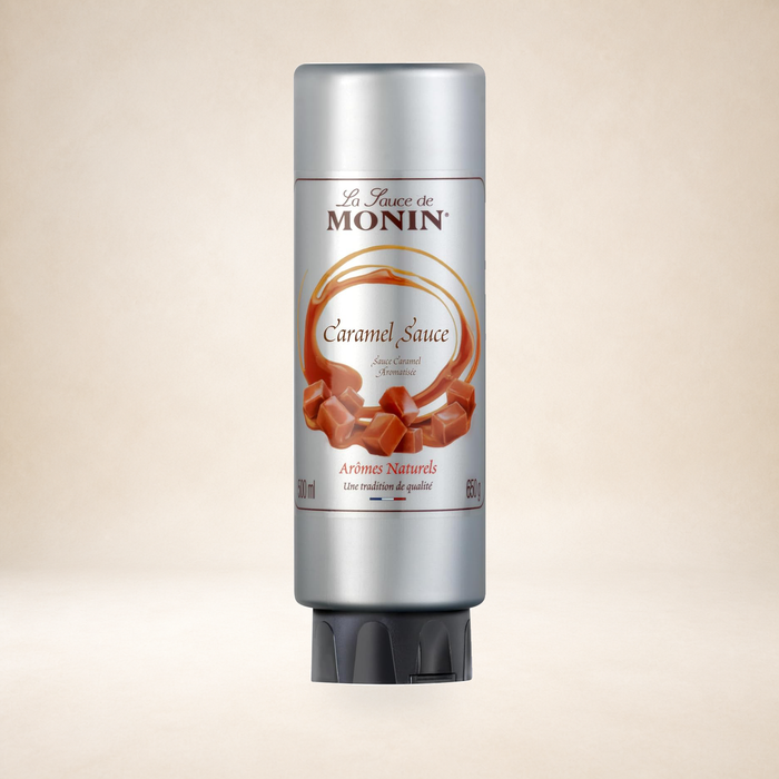 Monin Plain Caramel Sauce 500ml on a warm studio background