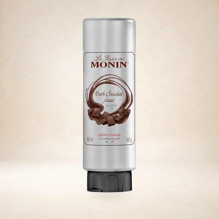 Monin Dark Chocolate Sauce 500ml on a warm studio background