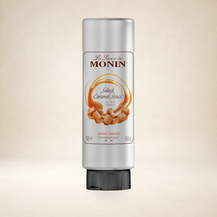 Monin Salted Caramel Sauce 500ml on a warm studio background