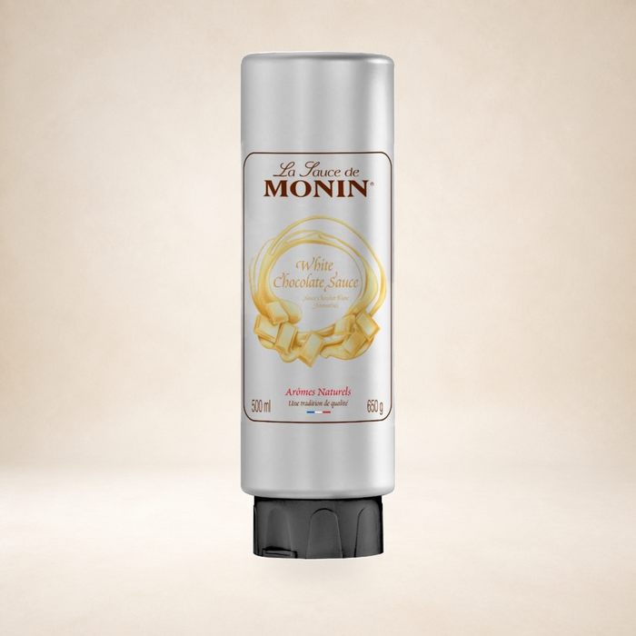 Monin White Chocolate Sauce 500ml on a warm studio background